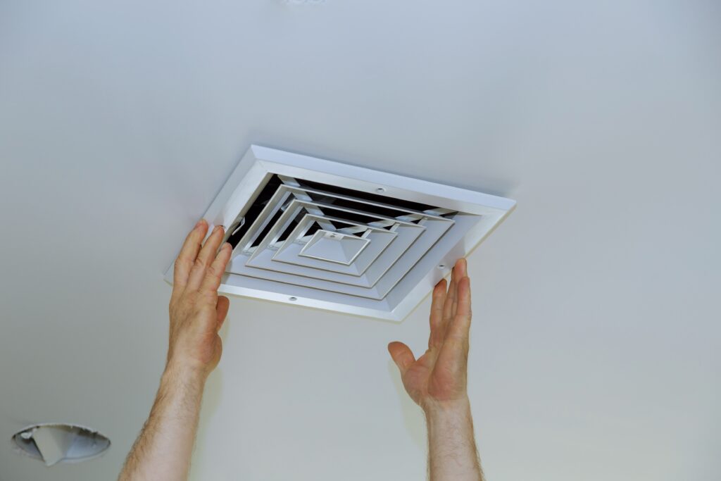 Preparing for Spring with Clean HVAC Ducts to Tackle Allergy Season 3 Close up man hand installing vent cover from ceiling