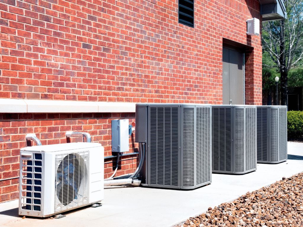 Small Hvac unit next to 3 big Hvac units
