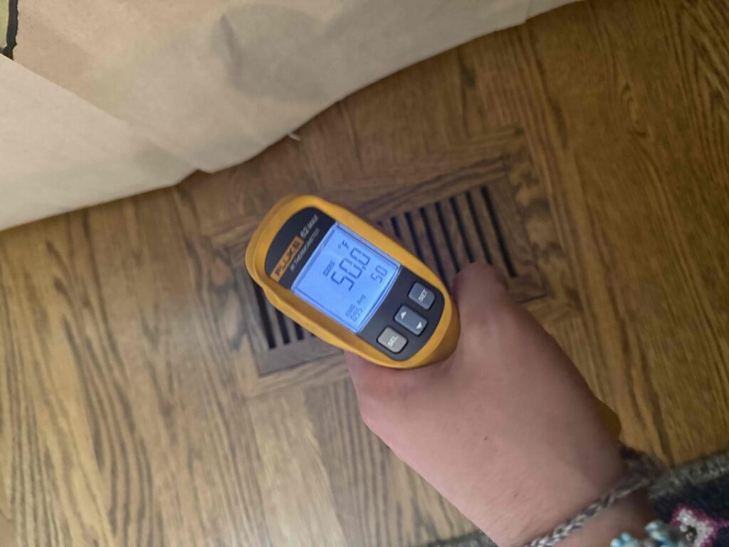 HVAC & Plumbing in Dover, MA 16 Technician measuring about 50 degree supply air at a register in Dover, MA