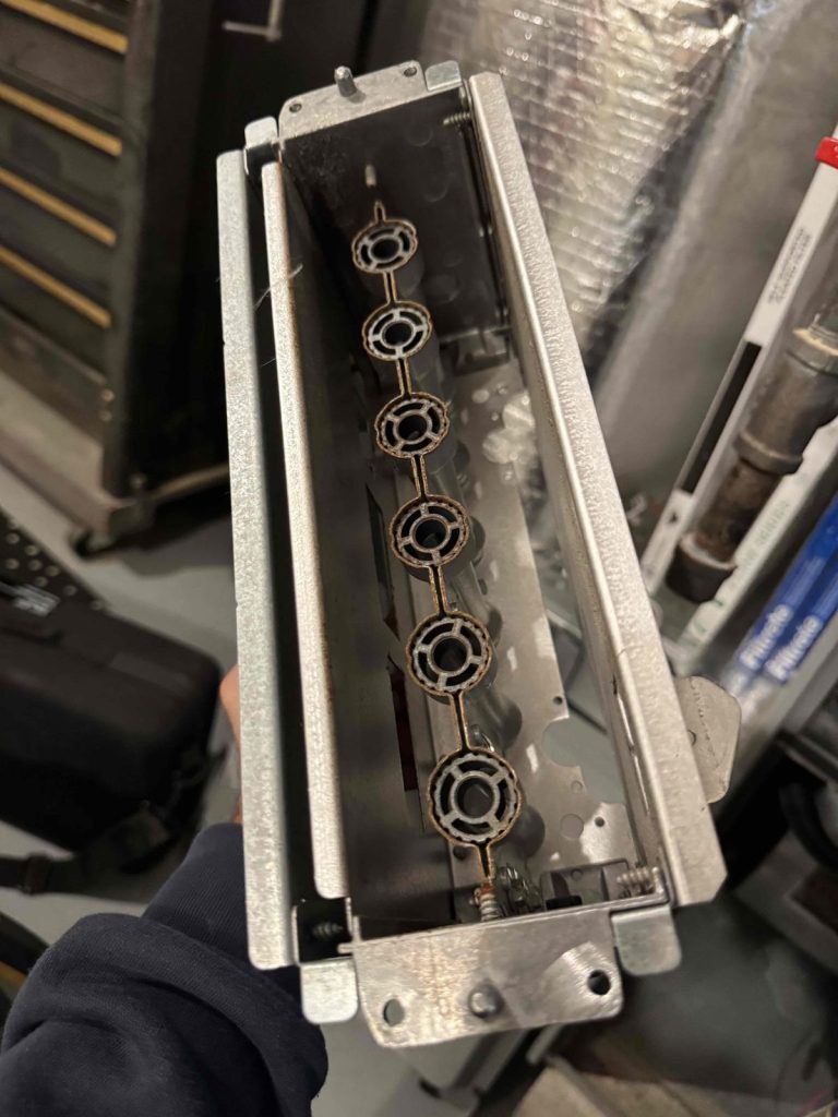 HVAC & Plumbing in Medway, MA 12 Burner assembly removed during a furnace inspection in Medway, MA