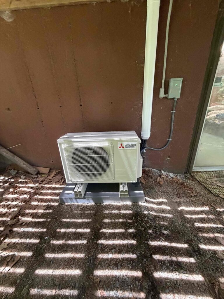 HVAC & Plumbing in Norfolk, MA 13 Mitsubishi ductless condenser on a new pad under a deck in Norfolk, MA